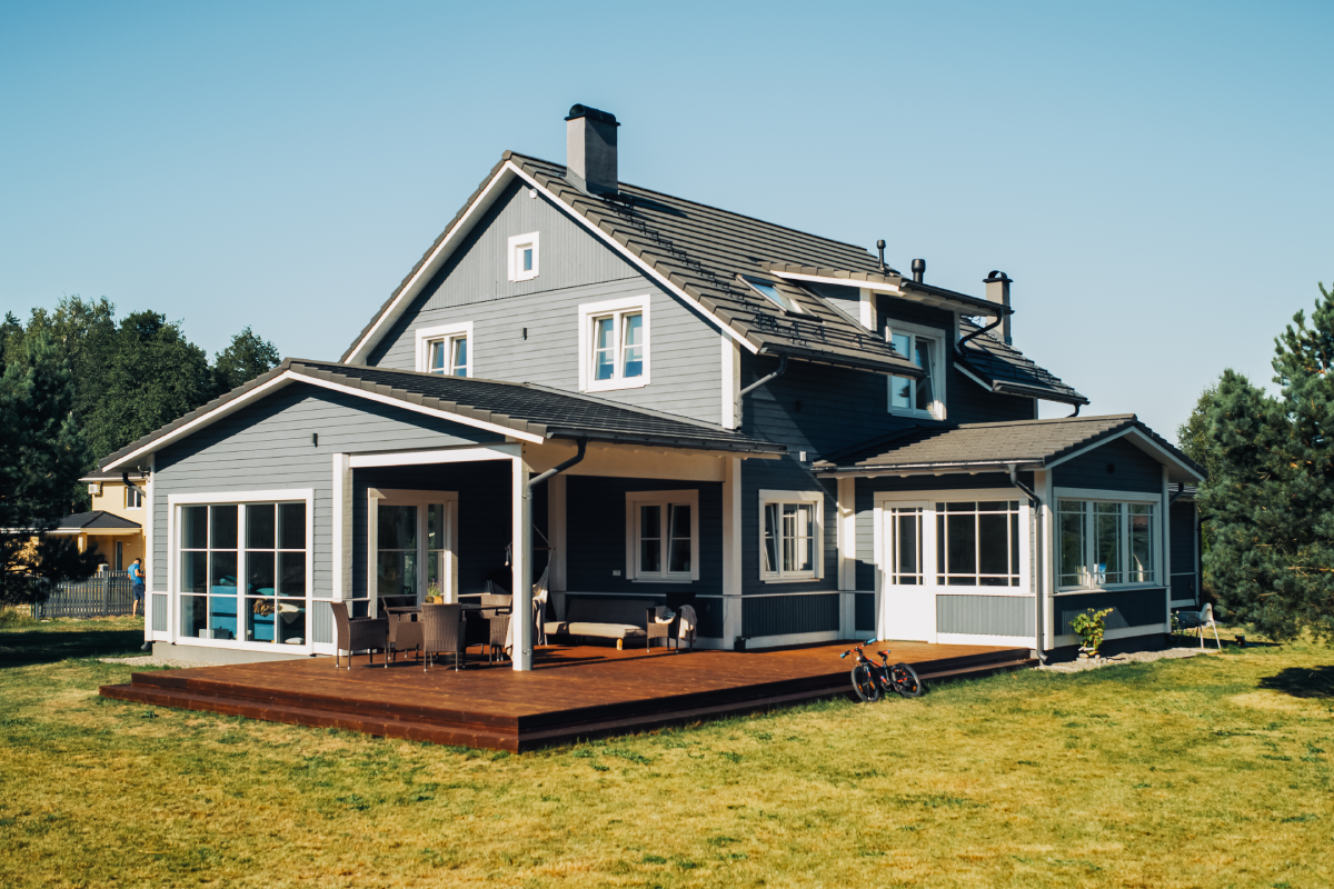 Modern gray house with wooden deck outside.